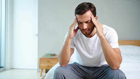 Мужчина держится руками за голову